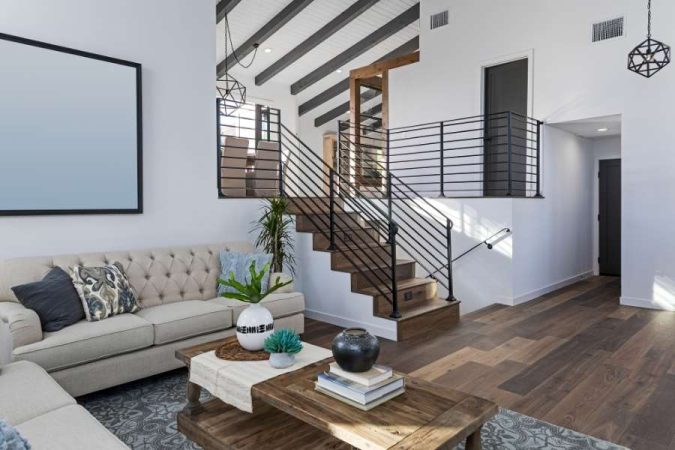 Un aménagement élégant et optimisé pour le petit salon avec un escalier moderne en arrière-plan.